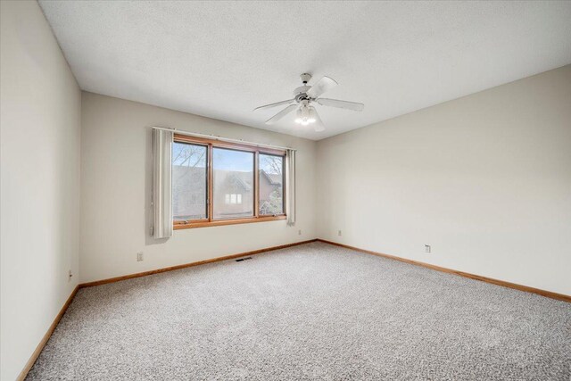 carpeted empty room featuring visible vents, a ceiling fan, baseboards, and a textured ceiling