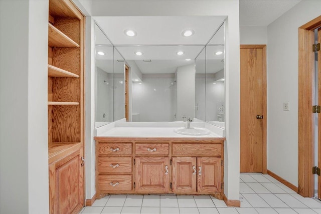 bathroom featuring recessed lighting, baseboards, tile patterned floors, and vanity