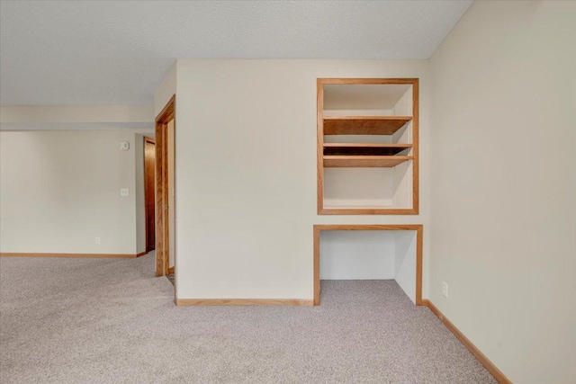 carpeted spare room featuring baseboards