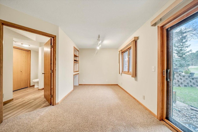 carpeted empty room featuring baseboards