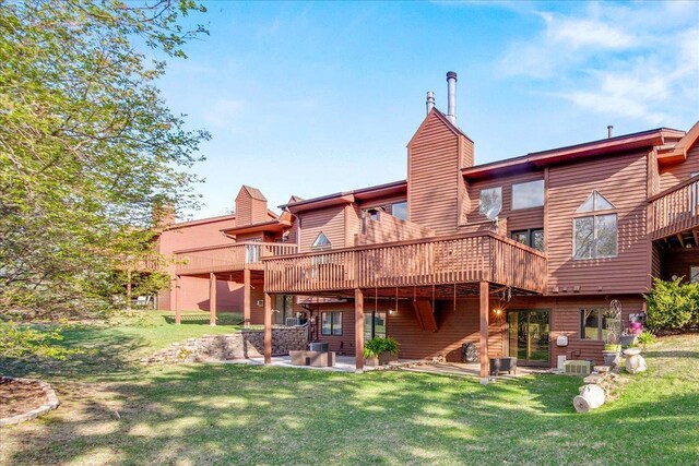 rear view of house featuring a lawn, a chimney, a patio, cooling unit, and a wooden deck