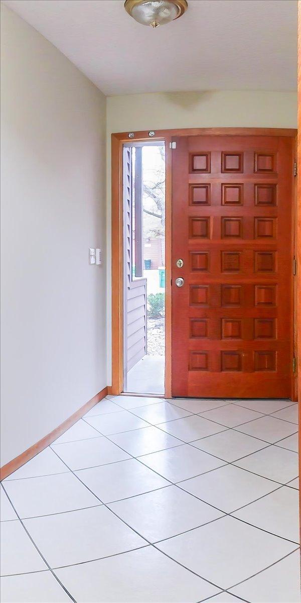 foyer entrance with light tile patterned floors and baseboards