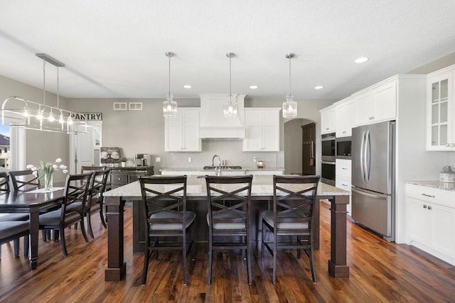 kitchen featuring white cabinets, appliances with stainless steel finishes, custom exhaust hood, and glass insert cabinets