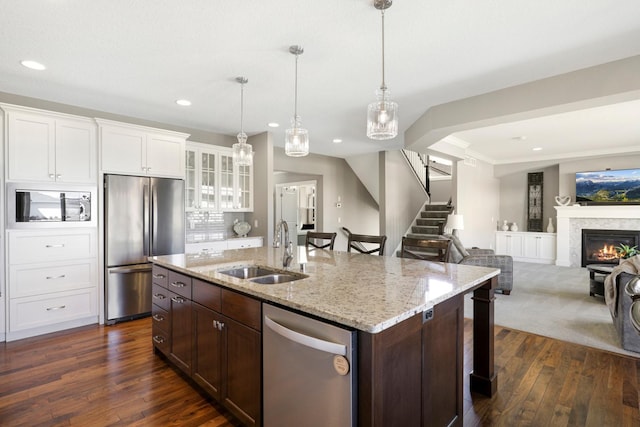 kitchen featuring appliances with stainless steel finishes, a sink, glass insert cabinets, white cabinetry, and dark wood-type flooring