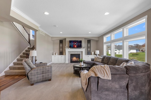 living area with crown molding, visible vents, stairs, and carpet