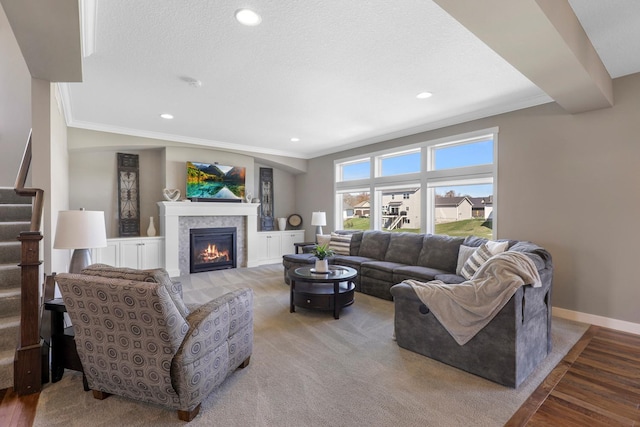 living area featuring ornamental molding, stairs, baseboards, recessed lighting, and a tile fireplace