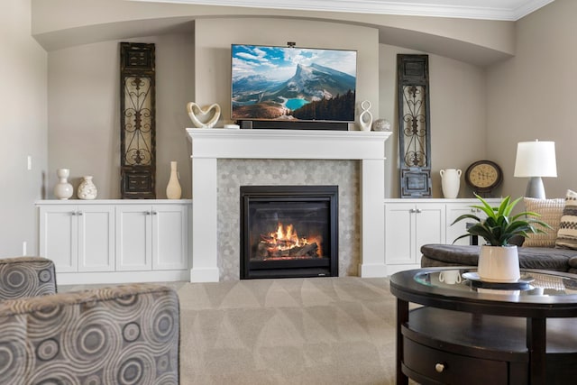 carpeted living area featuring a glass covered fireplace and crown molding