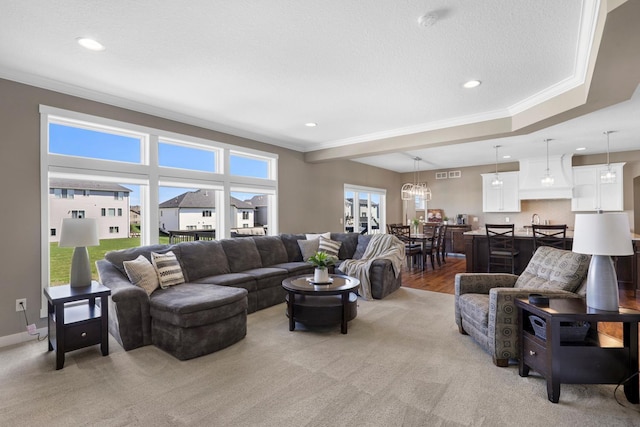 living room with crown molding, visible vents, and light colored carpet