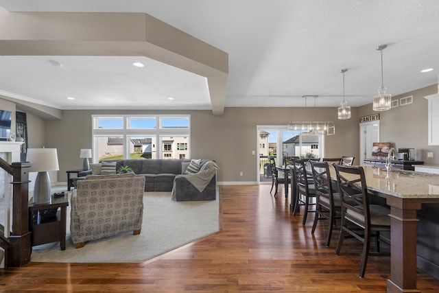 living area with recessed lighting, dark wood finished floors, and baseboards