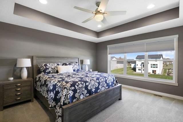 carpeted bedroom with visible vents, baseboards, ceiling fan, recessed lighting, and a raised ceiling