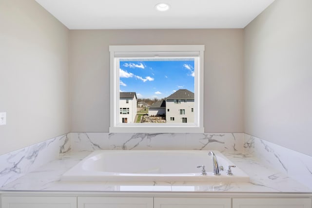 bathroom with recessed lighting and a garden tub