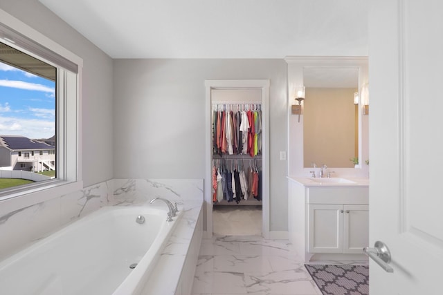 bathroom featuring vanity, marble finish floor, a garden tub, and a wealth of natural light