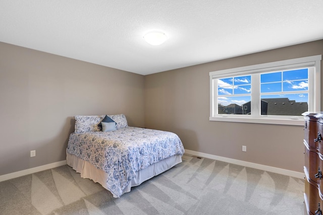 bedroom with baseboards and light carpet