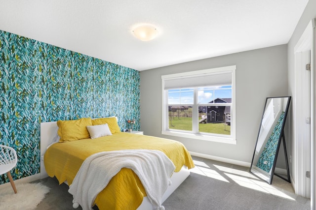 carpeted bedroom featuring baseboards, an accent wall, and wallpapered walls