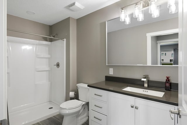 full bath featuring vanity, toilet, a shower, and visible vents