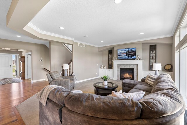 1149 167th Ave NW, Andover, MN 55304 - living room with stairway, a tiled fireplace, baseboards, ornamental molding, and recessed lighting