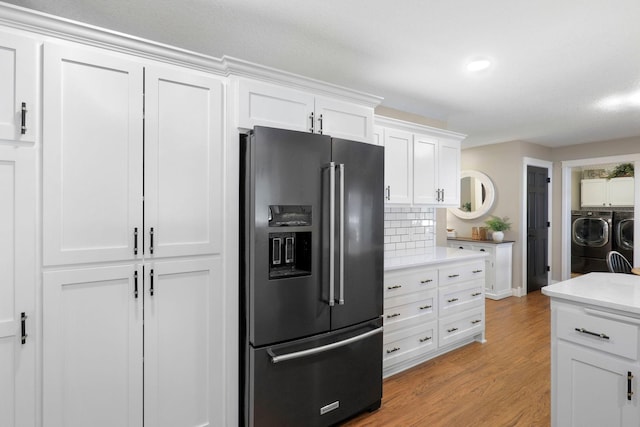 36090 Helium St NW, Wyanett Twp, MN 55371 - kitchen featuring fridge with ice dispenser, washing machine and dryer, light countertops, light wood-type flooring, and decorative backsplash