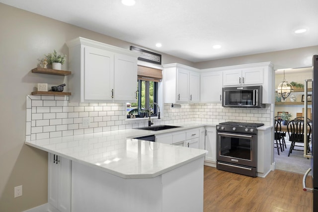 36090 Helium St NW, Wyanett Twp, MN 55371 - kitchen with stainless steel appliances, a peninsula, white cabinets, open shelves, and recessed lighting