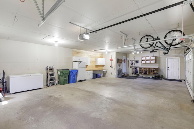 36090 Helium St NW, Wyanett Twp, MN 55371 - garage featuring freestanding refrigerator, a garage door opener, and refrigerator
