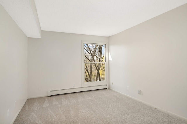 spare room with baseboard heating, baseboards, and carpet flooring