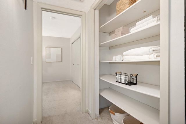 hall featuring baseboards and carpet