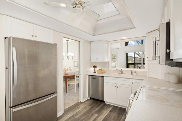kitchen with white cabinets, a sink, light countertops, dark wood-type flooring, and appliances with stainless steel finishes