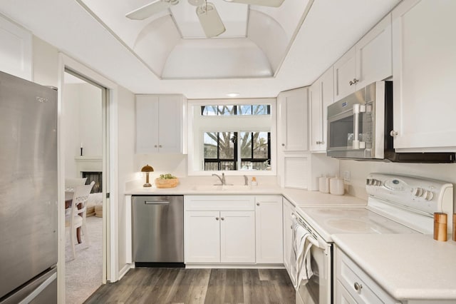 kitchen with a ceiling fan, a sink, stainless steel appliances, light countertops, and white cabinets