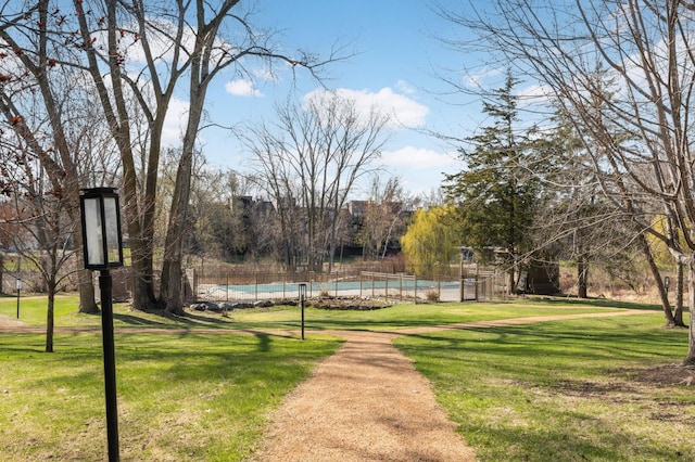 view of community featuring fence, a pool, and a yard