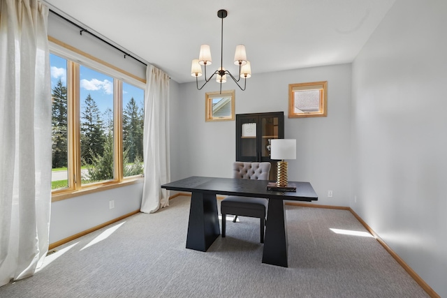 unfurnished office featuring baseboards, carpet flooring, a chandelier, and a healthy amount of sunlight