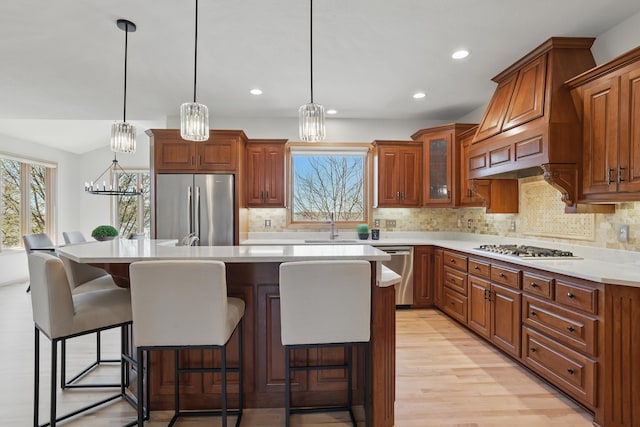 kitchen featuring a sink, plenty of natural light, stainless steel appliances, and brown cabinets