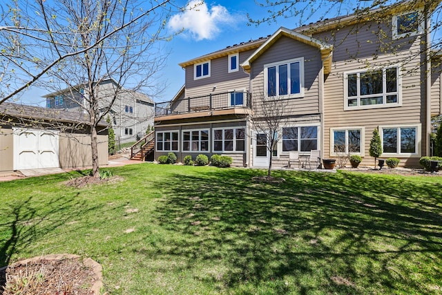 rear view of house featuring a lawn, an outbuilding, stairway, a balcony, and a shed
