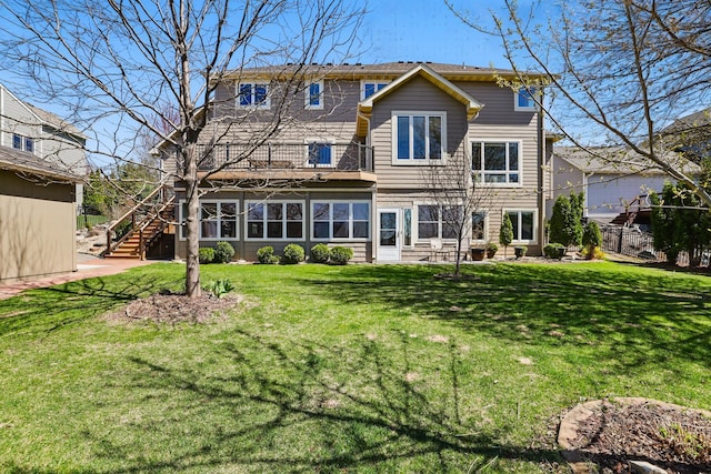 back of house featuring a yard, fence, a balcony, and stairway