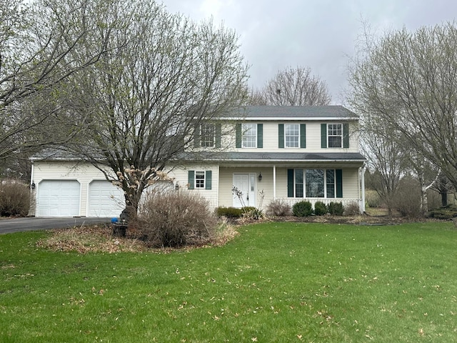 view of front facade with a garage, aphalt driveway, and a front yard