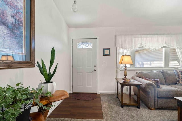 foyer with wood finished floors, lofted ceiling, and baseboards