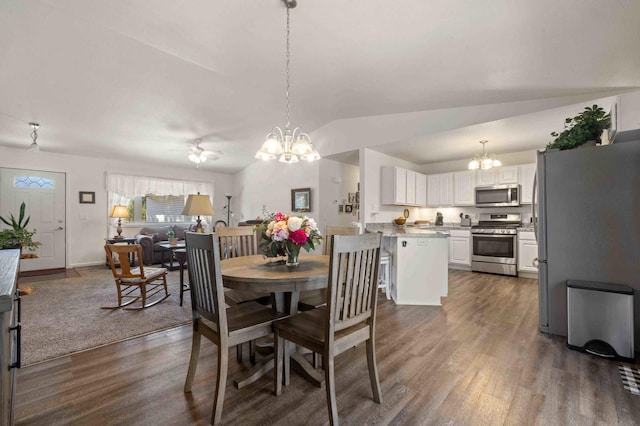 dining space with dark wood-type flooring, lofted ceiling, baseboards, and an inviting chandelier