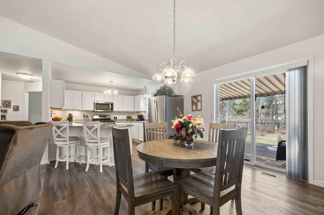 dining room featuring lofted ceiling, visible vents, an inviting chandelier, and dark wood finished floors