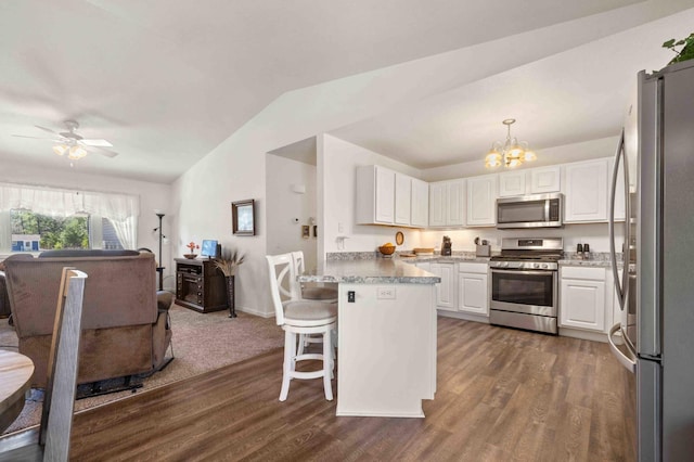 kitchen featuring lofted ceiling, dark wood-style floors, white cabinetry, and appliances with stainless steel finishes