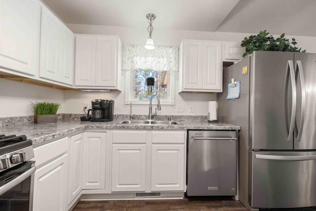 kitchen featuring light countertops, white cabinetry, a sink, appliances with stainless steel finishes, and dark wood-style flooring