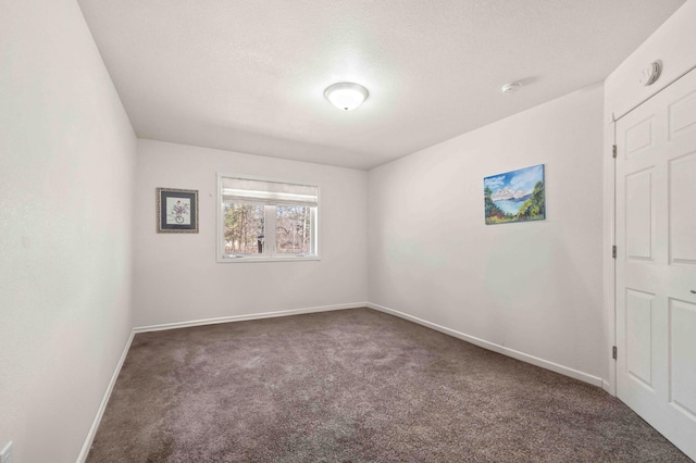 unfurnished room with baseboards and carpet flooring