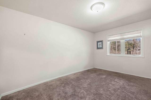 carpeted empty room featuring baseboards