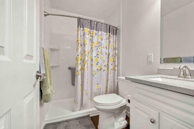 full bath with vanity, toilet, and a stall shower
