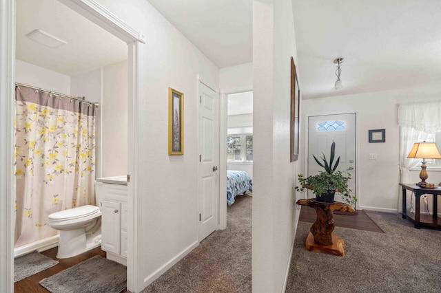 bathroom featuring toilet, vanity, baseboards, a shower with shower curtain, and ensuite bathroom
