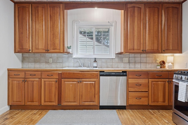 491 Burlington Rd, Saint Paul, MN 55119 - kitchen featuring appliances with stainless steel finishes, light wood-style flooring, brown cabinetry, light countertops, and backsplash