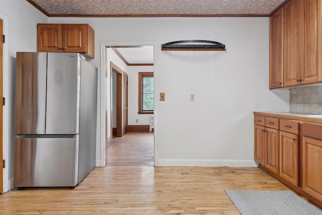 491 Burlington Rd, Saint Paul, MN 55119 - kitchen with freestanding refrigerator, crown molding, light wood-type flooring, brown cabinets, and light countertops