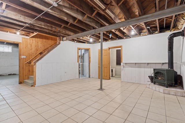 491 Burlington Rd, Saint Paul, MN 55119 - basement featuring a wood stove, stairway, tile patterned flooring, and wood walls