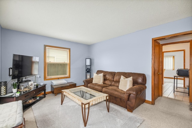 carpeted living area with plenty of natural light and baseboards