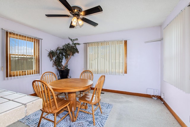dining room featuring carpet floors, a ceiling fan, and baseboards