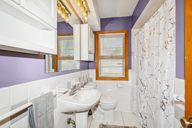 full bathroom featuring wainscoting, toilet, tile patterned floors, tile walls, and a shower with curtain