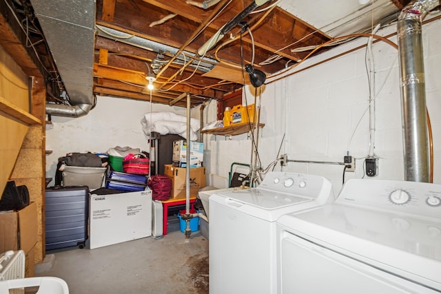 washroom with concrete block wall, laundry area, and independent washer and dryer