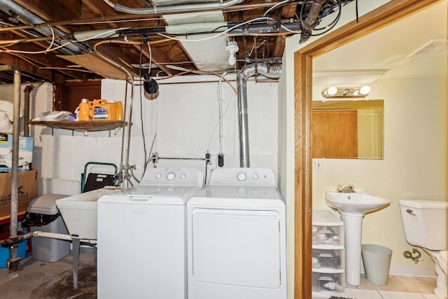 clothes washing area with laundry area, a sink, and washing machine and clothes dryer